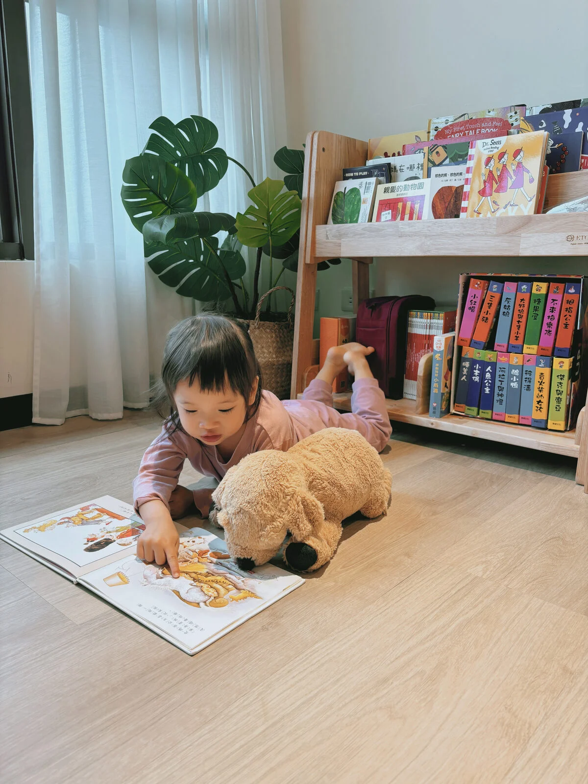 孩子在幼兒實木家具書架旁自己看書